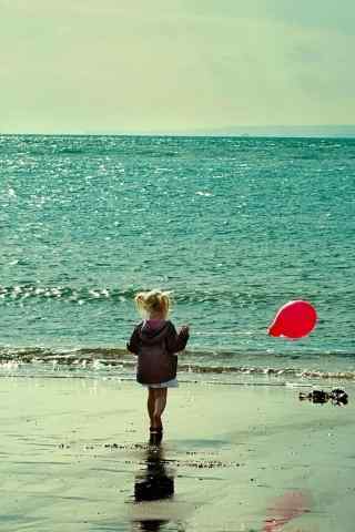 海边拿着红气球的可爱小女孩手机壁纸