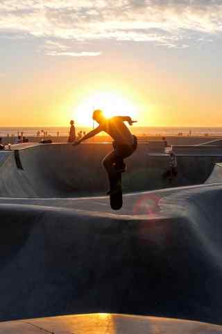 夕阳下的滑板运动爱好者手机壁纸图片